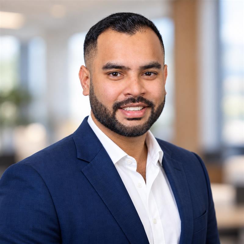 Rahul Bedi, Team Lead and Mortgage Broker at Team Active Mortgage, smiling in a navy suit and white shirt
