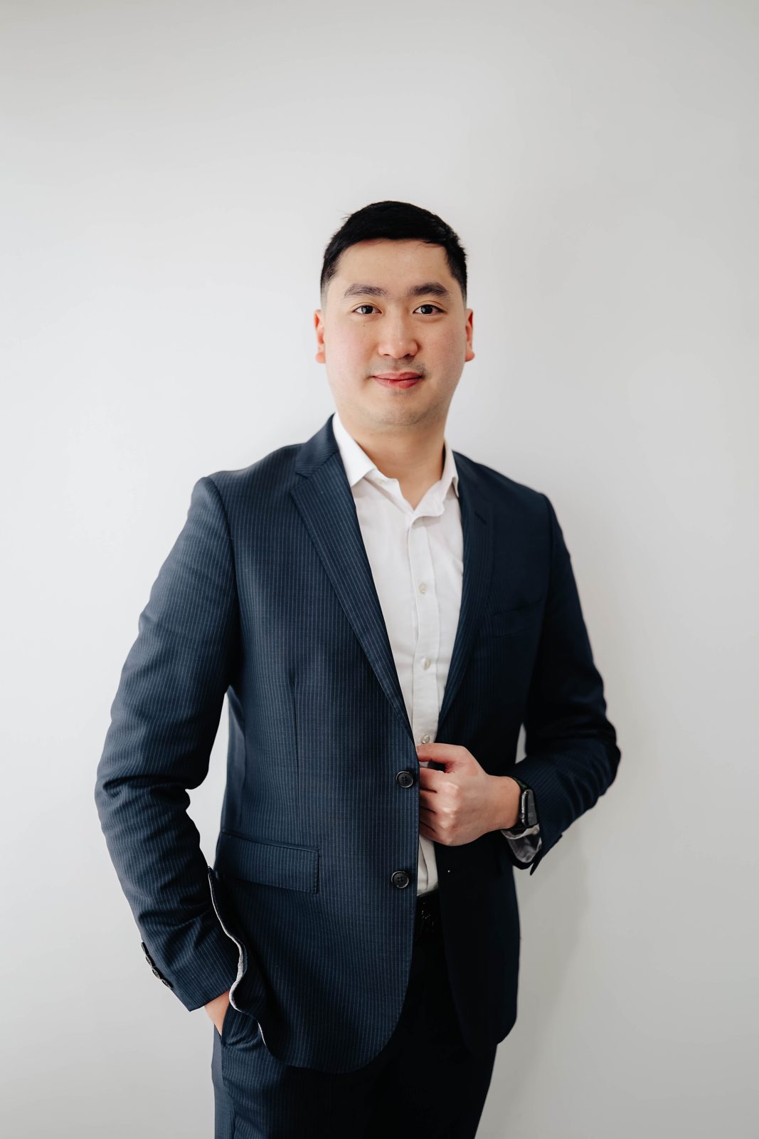 Tom Lukman, Associate Mortgage Broker, standing with hands at his jacket
