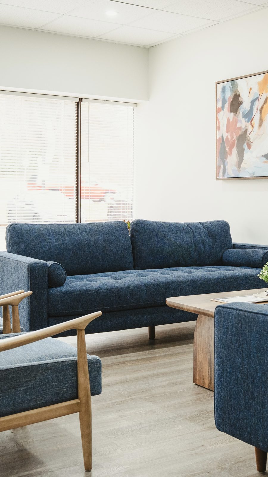 Client lounge with a navy sofa and armchairs at the Team Active Mortgage Bedford office