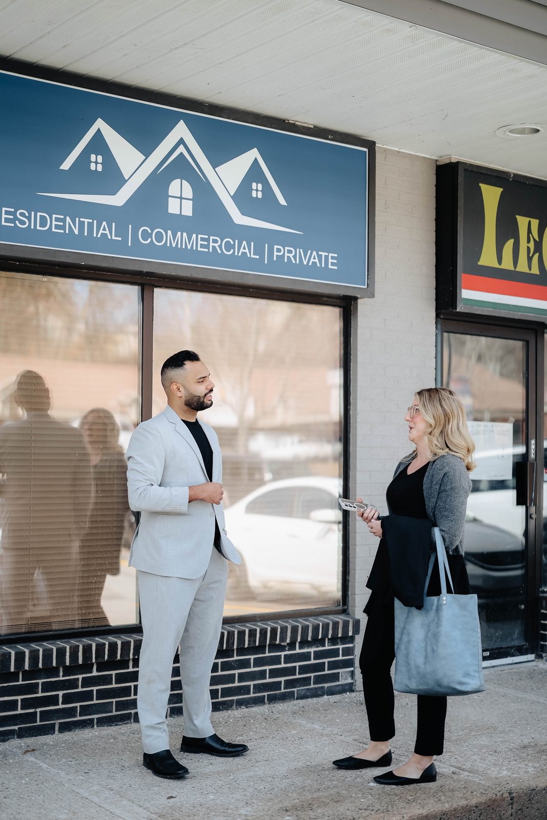 Two Team Active Mortgage team members talking outside the Bedford office storefront